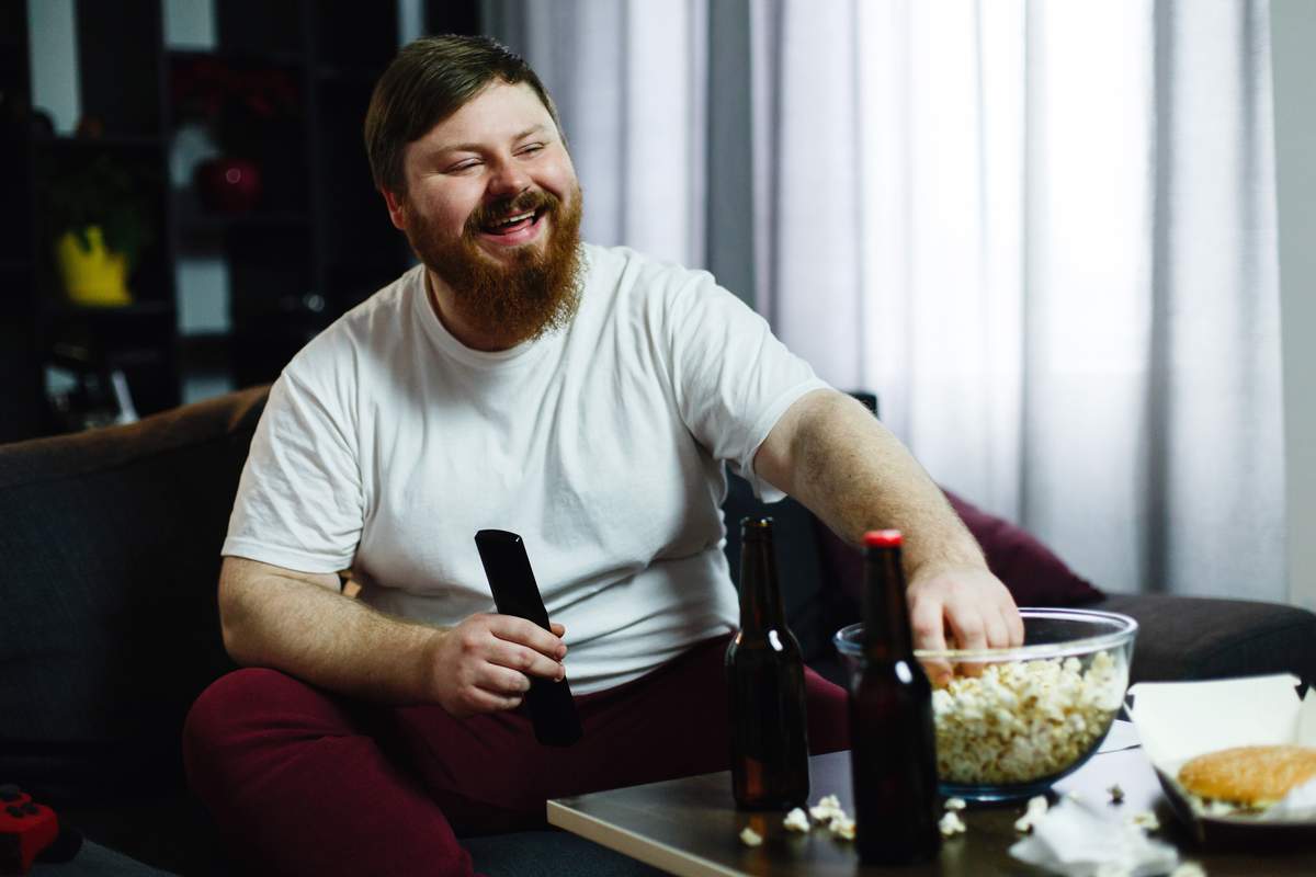 Homme en surpoids qui regarde la télé